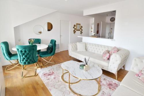 un salon avec un canapé, une table et des chaises dans l'établissement L'Amandier Disneyland Paris 4 personnes et 1 bébé, à Bailly-Romainvilliers