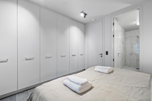 a white bedroom with a large bed with white cabinets at Harbour Lux 3BR & 2BA in the Heart of the City with Free Parking in Reykjavík
