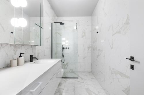 a white bathroom with a sink and a shower at Harbour Lux 3BR & 2BA in the Heart of the City with Free Parking in Reykjavík