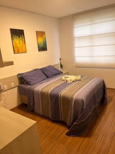 ein Schlafzimmer mit einem großen Bett in einem Zimmer in der Unterkunft Flat - Suíte Trocadéro - 112 in Lagoa Santa