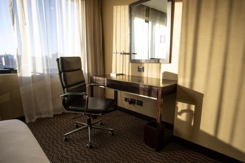 a hotel room with a desk and a chair at Hilton Garden Inn Tucuman in San Miguel de Tucumán