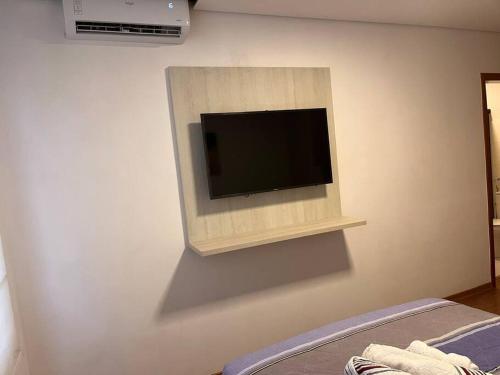 TV de pantalla plana en la esquina de una pared en Flat - Suíte Trocadéro - 112, en Lagoa Santa