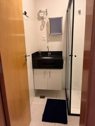 a small bathroom with a sink and a mirror at Flat - Suíte Trocadéro - 112 in Lagoa Santa