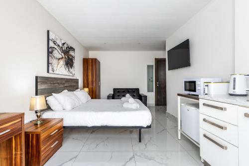 a hotel room with a bed and a kitchen at Studio Penthouse with kitchenette and side seaview at the new Olo living in Paceville