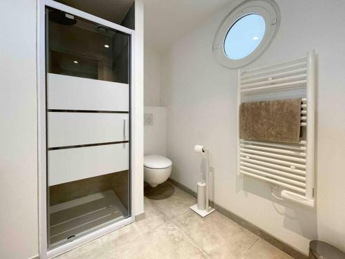 een witte badkamer met een toilet en een raam bij le mirage in Beausoleil