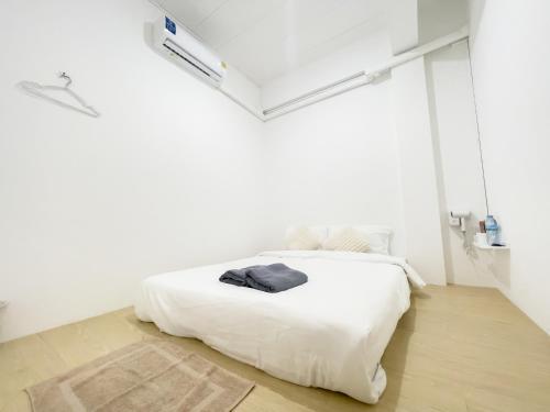 a white bedroom with a white bed in a room at TRANSIT Donmueang Airport HOSTEL in Thung Si Kan