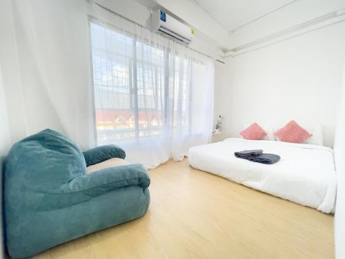 Thung Si Kan的住宿－TRANSIT Donmueang Airport HOSTEL，一间卧室配有一张床和一张蓝色椅子