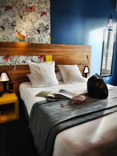 a bedroom with a bed with a book on it at Best Western Hotel De Paris in Laval