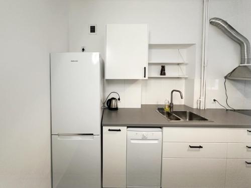 La cuisine blanche est équipée d'un réfrigérateur et d'un évier. dans l'établissement Fantastic - NS54 Room O, à Varsovie