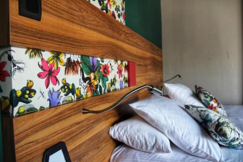a bed with a wooden head board with pillows on it at Best Western Hotel De Paris in Laval