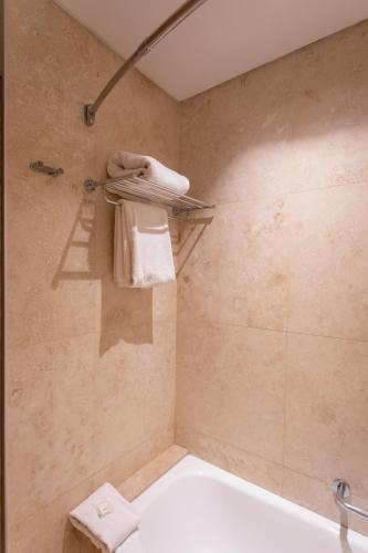 a bathroom with a shower with a toilet and towels at Hilton Garden Inn Tucuman in San Miguel de Tucumán