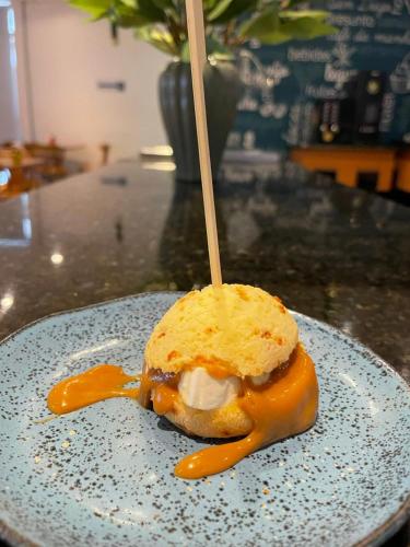 a sandwich on a plate with a stick in it at San Diego Express Barro Preto in Belo Horizonte