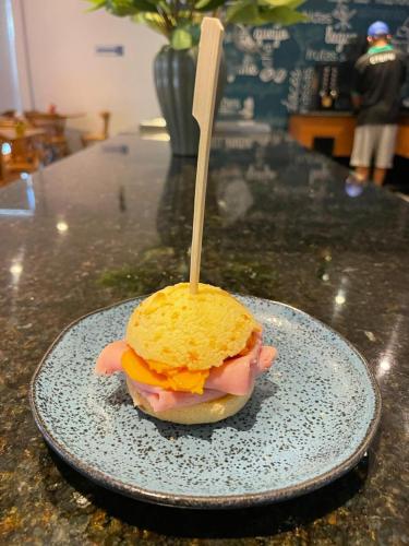 a sandwich on a plate with a wooden stick in it at San Diego Express Barro Preto in Belo Horizonte