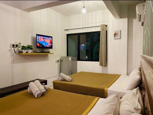 um quarto com 2 camas e uma televisão de ecrã plano em Pangkor BeachWalk Studio em Ilha de Pangkor