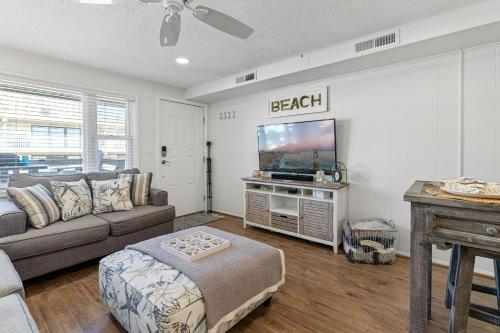 sala de estar con sofá y TV de pantalla plana en Ocean Block Condo 100 Steps From the Beach en Ocean City