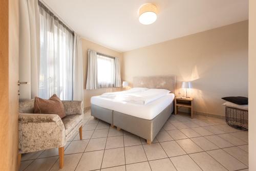 a bedroom with a bed and a couch and a chair at Weingut Weidlhof - Suite & Breakfast - Vacation for wine lovers in Caldaro