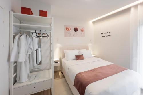a white bedroom with a bed and a closet at City Palace Trikala in Tríkala
