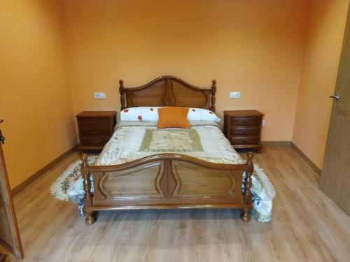 a bedroom with a wooden bed and two night stands at Casa Souto in Santa Comba