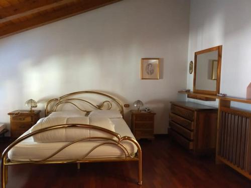 een slaapkamer met een bed met een spiegel en een dressoir bij Spazioso appartamento Nico in Dimaro