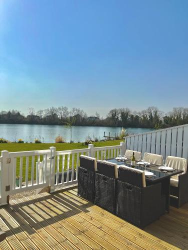 a patio with a table and chairs on a deck at Medway Lodge in South Cerney