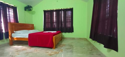 a bedroom with a bed with a red table at Empire HomeStay in Kalpetta