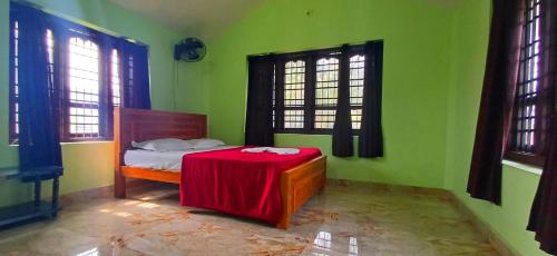 a bedroom with a bed with a red table in it at Empire HomeStay in Kalpetta