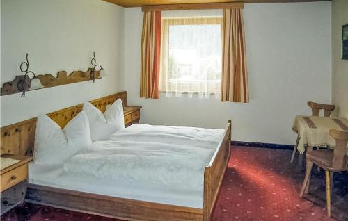 ペットイ・アム・アールベルクにあるNice Apartment In Pettneu Am Arlberg With 2 Bedrooms And Wifiのベッドルーム(大きな白いベッド1台、テーブル付)