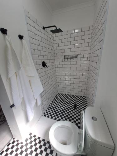 a bathroom with a toilet and a black and white tile floor at 2 On Greeff in Graaff-Reinet