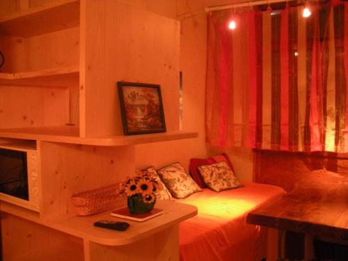 サン・ラリー・スランにあるStudio Saint Lary Soulanのベッド1台、花のテーブルが備わる小さな客室です。