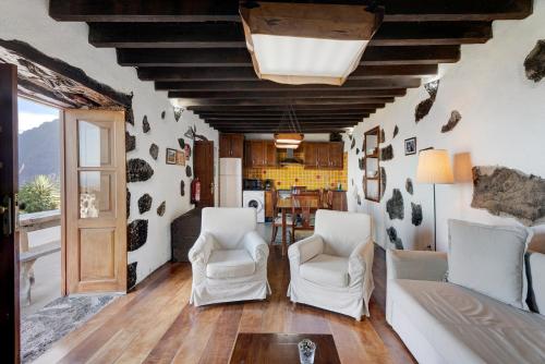 a living room with two white chairs and a table at El Lagar in Frontera