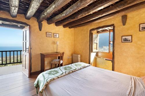 a bedroom with a bed and a large window at El Lagar in Frontera