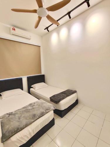 a room with two beds and a ceiling fan at Sakura 1 Homestay Kampar Landed in Kampar