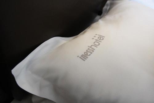 a white pillow with the word outbreak written on it at Iness Hotel in Łódź