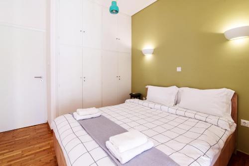 a bedroom with a bed with two towels on it at Cozy - Bright & New apart. - Downtown in Athens