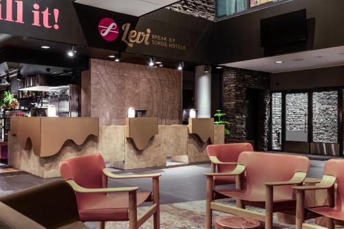 a waiting room at a restaurant with pink chairs at Break Sokos Hotel Levi in Levi
