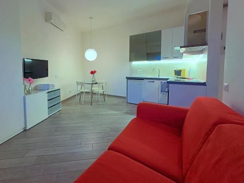 sala de estar con sofá rojo y cocina en Appartme Sarca 59, en Milán