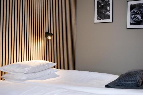 a bedroom with a white bed with a striped wall at Hotell Nyboholm in Ulricehamn