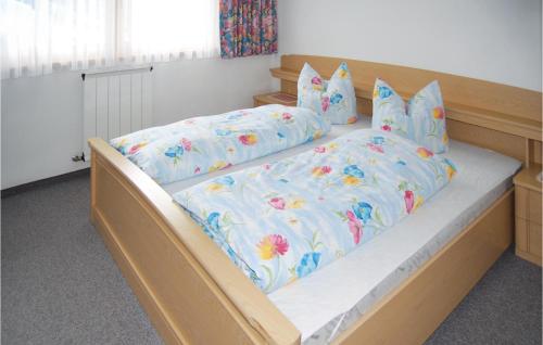 カップルにあるAmazing Apartment In Kappl With 2 Bedrooms And Wifiの花柄の掛け布団と枕付きのベッド