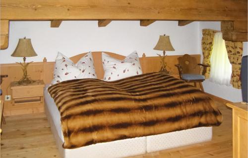 Cozy Home In Kitzbhel With House A Mountain View في Haselwand: غرفة نوم مع سرير وبطانية حمار الوحشي
