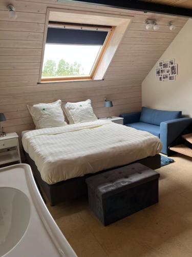 Schlafzimmer mit einem Bett, einer Badewanne und einem Fenster in der Unterkunft Vakantiewoning - Ter Douve in Heuvelland