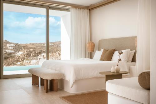 a bedroom with a bed and a large window at Mykonos Flow - Super Paradise in Super Paradise Beach