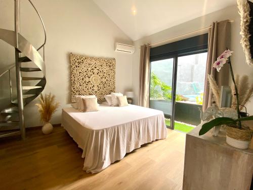 a bedroom with a bed and a large window at Villa L’Eden Zen face à l océan in Saint-Pierre