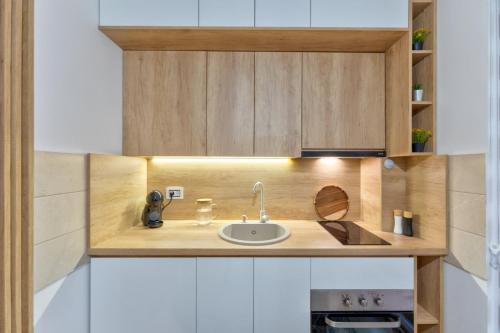 ズラティボールにあるApartman Martinovicのシンクと木製のキャビネットを備えたキッチン