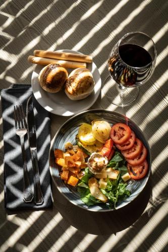 a table with two plates of food and a glass of wine at Hilton Garden Inn Tucuman in San Miguel de Tucumán