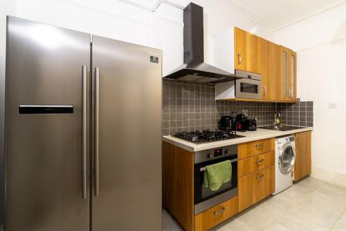 eine Küche mit einem Kühlschrank aus Edelstahl und einem Herd in der Unterkunft (Covent Garden) Cozy Apartment Central London in London