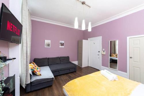 a living room with a couch and a tv at (Covent Garden) Cozy Apartment Central London in London