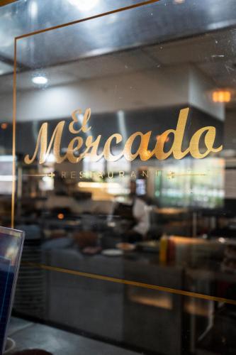 a mecca sign on the window of a restaurant at Hilton Garden Inn Tucuman in San Miguel de Tucumán