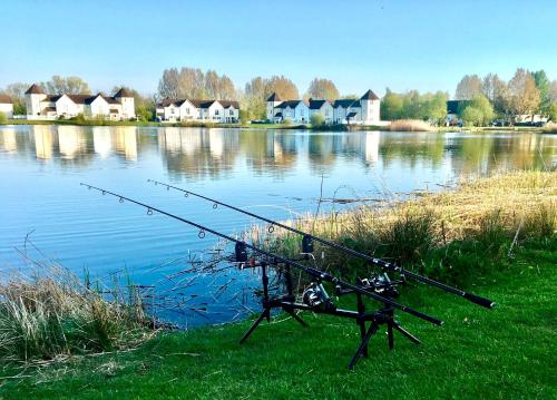 a fishing device sitting on the side of a lake at Spinnaker Lodge · Cotswolds Lakeside Home in South Cerney
