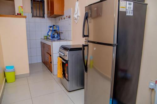 eine Küche mit einem Kühlschrank aus Edelstahl und einem Herd in der Unterkunft IT IS WELL HOMES in Kisii