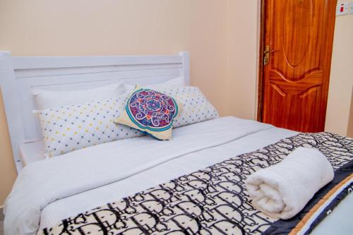 ein Bett mit einem Kissen und einem Handtuch darauf in der Unterkunft IT IS WELL HOMES in Kisii